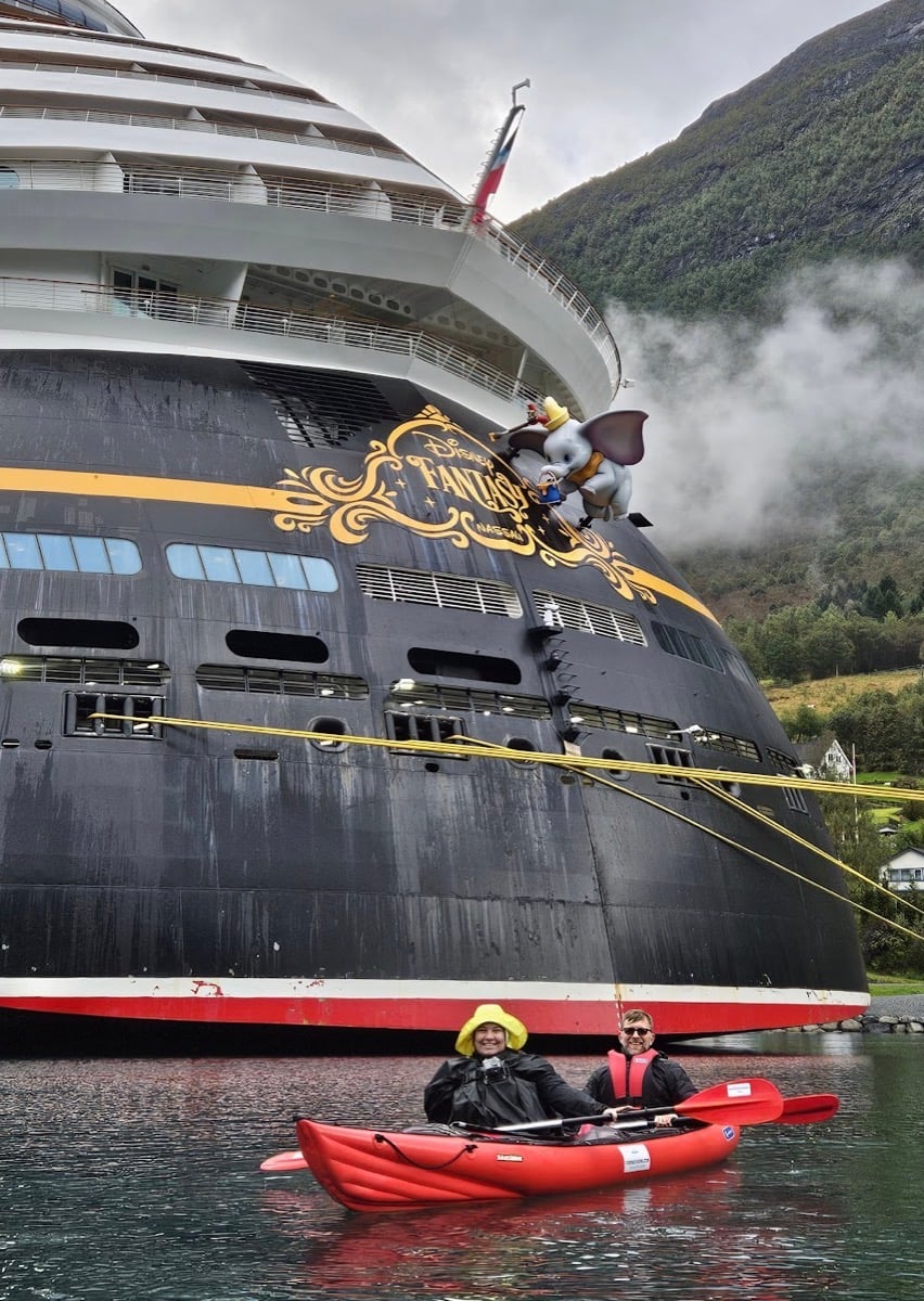 Audrey and Billy kayaking behind Disney Fantasy in Olden Norway