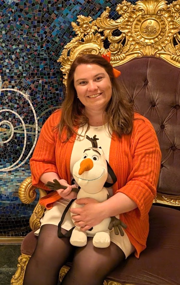 Audrey on a throne on Disney Fantasy, holding Olaf